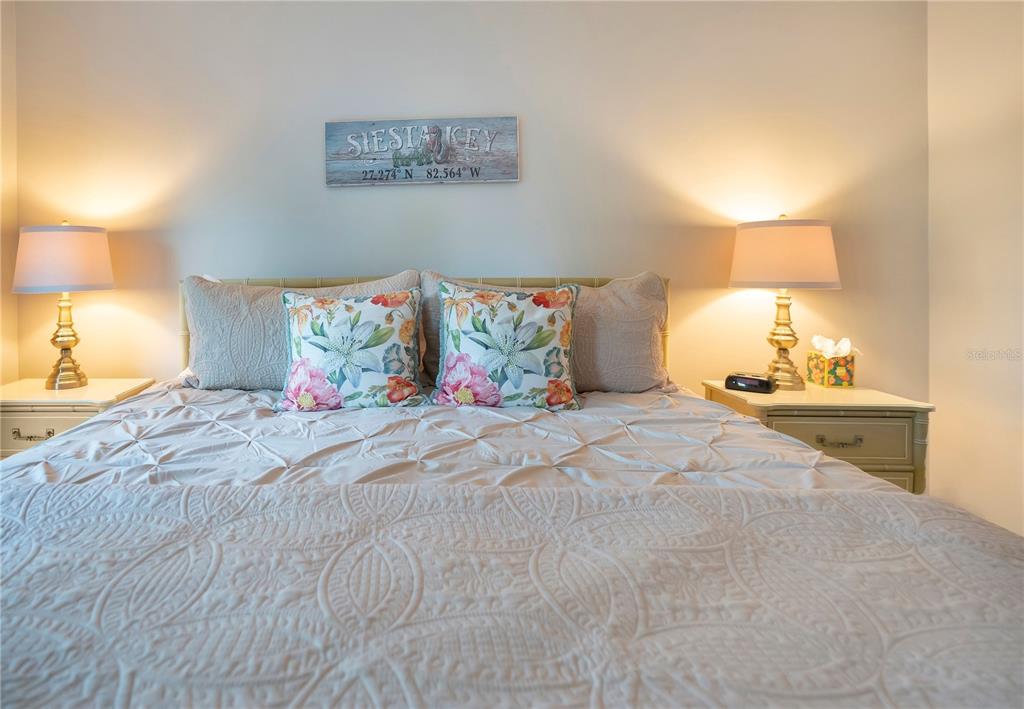 1646 Stickney Point Road, Unit 1646101 Sarasota, FL 34231 - Photo 21 of 67 a spacious bedroom with a bed and a lamp on dresser