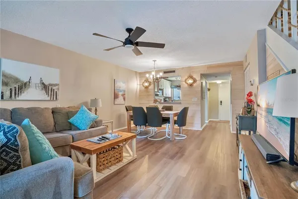 a living room with furniture a chandelier and a table
