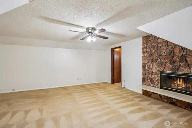 a view of empty room with fireplace and fan