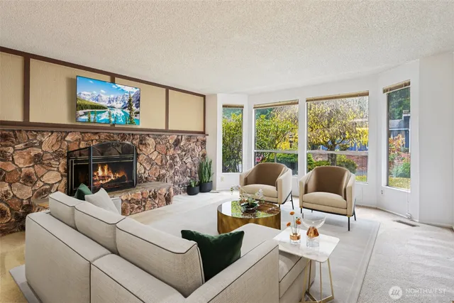 a living room with furniture a fireplace and a floor to ceiling window
