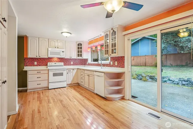 a kitchen that has a lot of cabinets and wooden floor