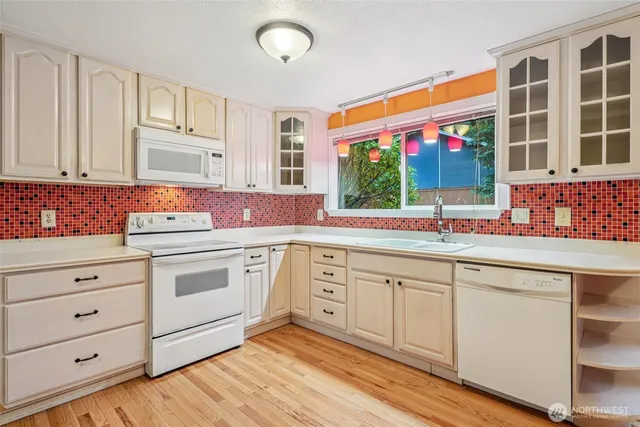 a kitchen with stainless steel appliances sink cabinets and window