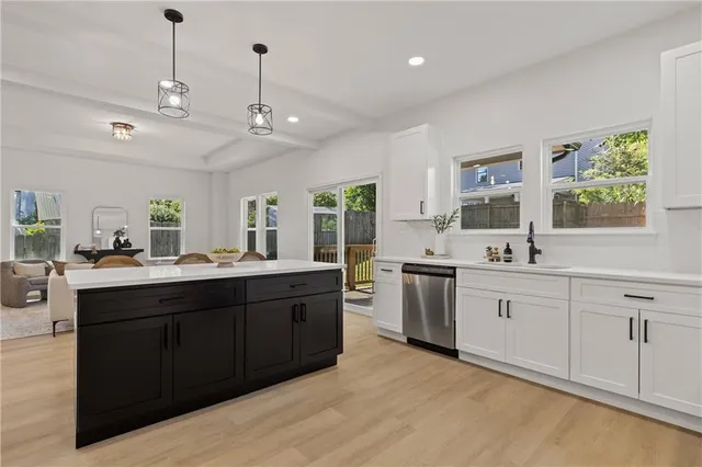 a large kitchen with kitchen island a sink stainless steel appliances and cabinets