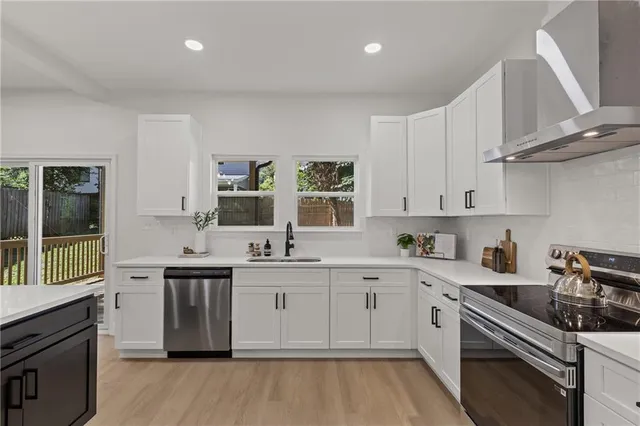 a kitchen with stainless steel appliances granite countertop a sink stove and cabinets