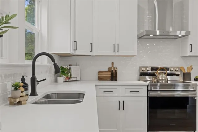 a kitchen with granite countertop a sink stainless steel appliances and cabinets