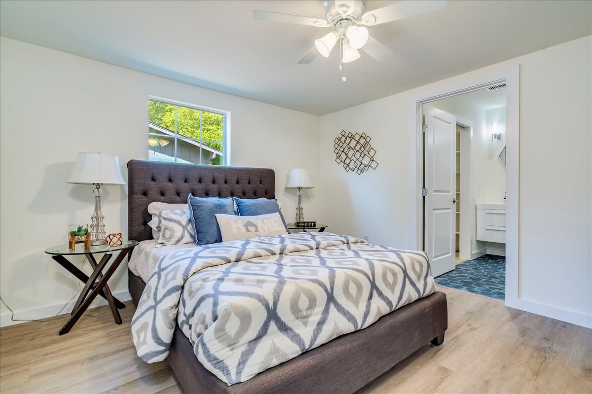 1120 Spur Street Austin, TX 78721 - Photo 11 of 31 a bedroom with a bed and a chandelier