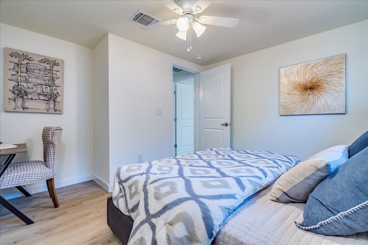 1120 Spur Street Austin, TX 78721 - Photo 12 of 31 a bedroom with a bed and a chandelier