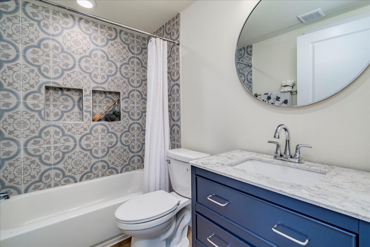 1120 Spur Street Austin, TX 78721 - Photo 19 of 31 a bathroom with a granite countertop sink a toilet and a mirror