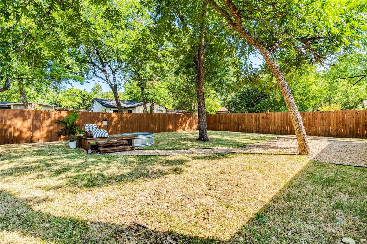 1120 Spur Street Austin, TX 78721 - Photo 25 of 31 a view of a backyard with large tree and wooden fence