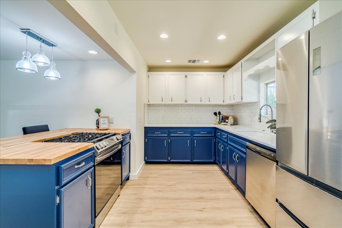 1120 Spur Street Austin, TX 78721 - Photo 7 of 31 a large kitchen with stainless steel appliances granite countertop a stove a sink dishwasher and a refrigerator