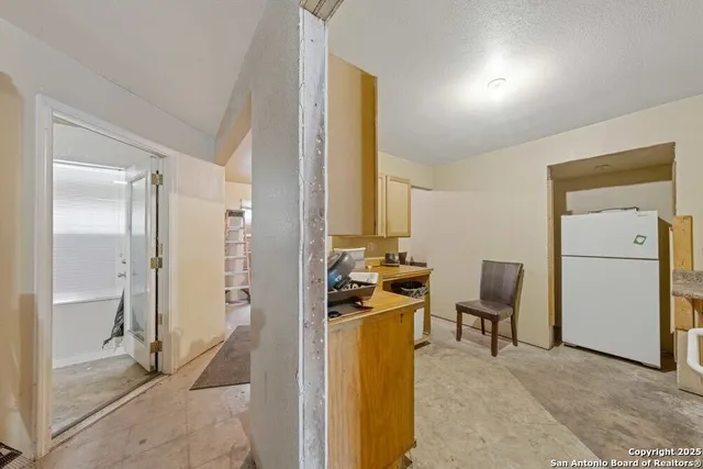 a view of a hallway with workspace and a window