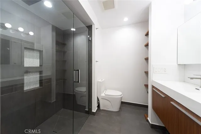 a bathroom with a toilet sink a mirror and shower