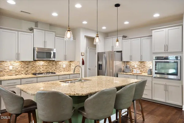 a kitchen with stainless steel appliances granite countertop a refrigerator microwave and stove