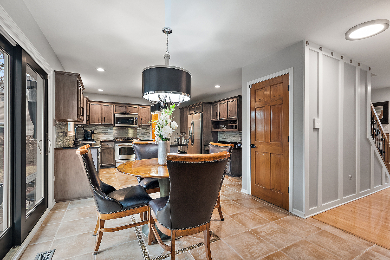806 Wescott Road Bolingbrook, IL 60440 - Photo 5 of 28 a view of a dining room and a kitchen with furniture a chandelier and wooden floor
