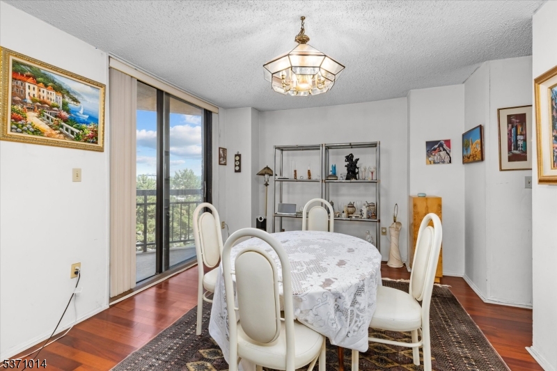 401 Harmon Cove Tower Secaucus, NJ 07094 - Photo 13 of 47 a dining room with furniture a chandelier and wooden floor