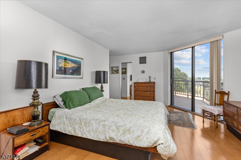 401 Harmon Cove Tower Secaucus, NJ 07094 - Photo 19 of 47 a spacious bedroom with a bed and wooden floor