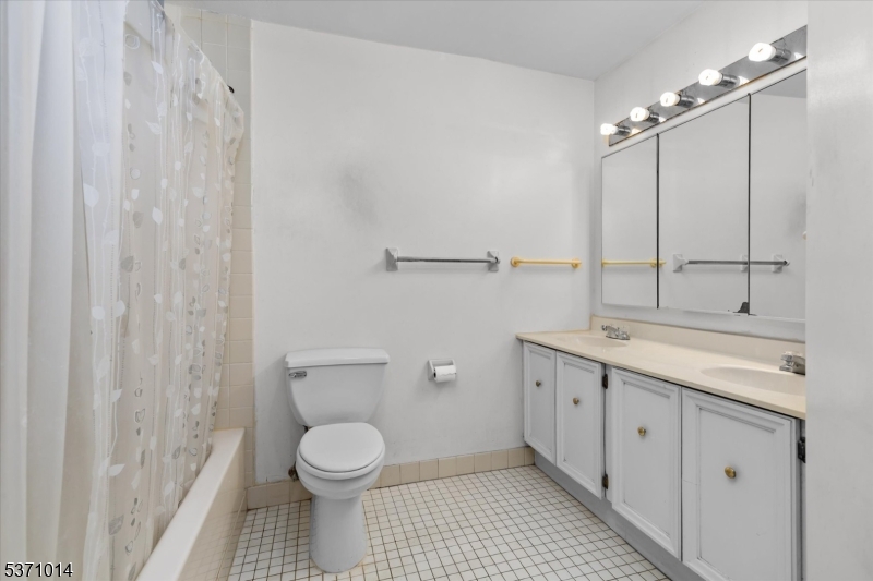 401 Harmon Cove Tower Secaucus, NJ 07094 - Photo 24 of 47 a bathroom with a granite countertop sink a toilet and a shower