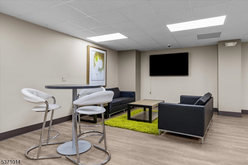 401 Harmon Cove Tower Secaucus, NJ 07094 - Photo 35 of 47 a living room with furniture and a flat screen tv