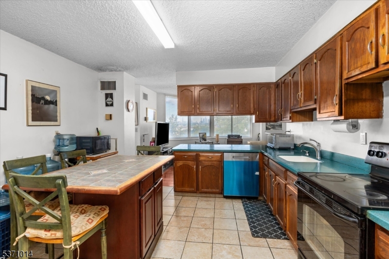 401 Harmon Cove Tower Secaucus, NJ 07094 - Photo 8 of 47 a kitchen with a stove sink and cabinets