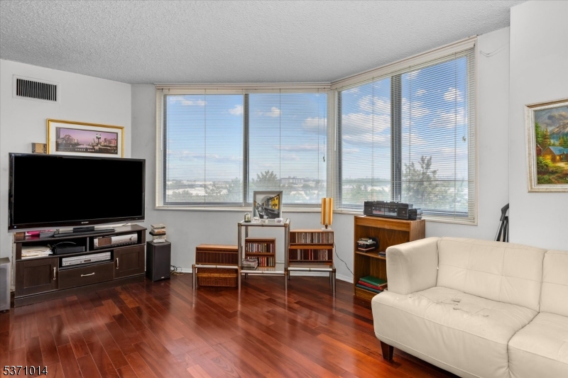 401 Harmon Cove Tower Secaucus, NJ 07094 - Photo 10 of 47 a living room with furniture and a flat screen tv