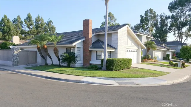 a front view of a house with a yard and potted plants