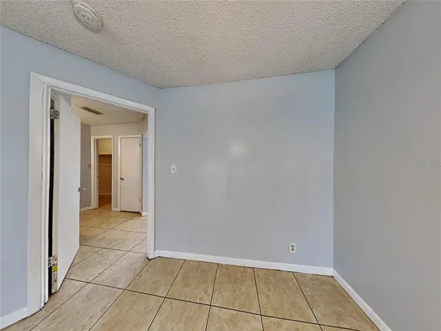 an empty room with wooden floor and chandelier