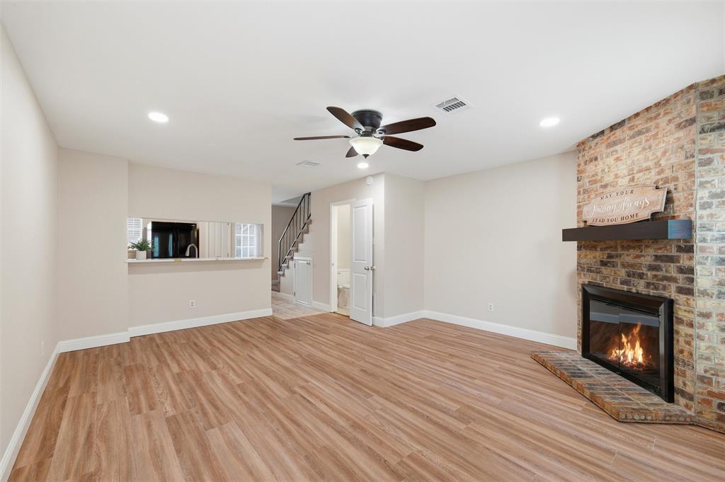 112 Churchill Lane Euless, TX 76039 - Photo 4 of 33 a view of a livingroom with a ceiling fan a fireplace and wooden floor