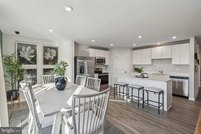 a kitchen with a dining table chairs and refrigerator