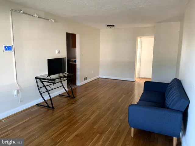 a view of a livingroom with lounge chair and wooden floor