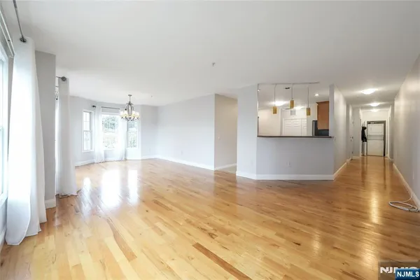 a view of a big room with wooden floor and a kitchen