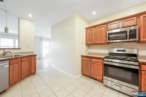 a kitchen with stainless steel appliances granite countertop a stove microwave and cabinets