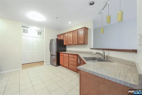 a kitchen with a sink refrigerator and cabinets
