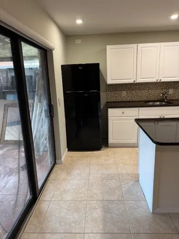a kitchen with granite countertop white cabinets and stainless steel appliances
