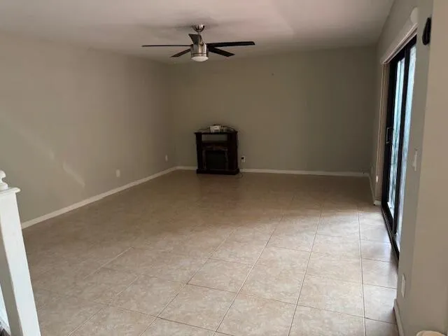an empty room with a ceiling fan and carpet
