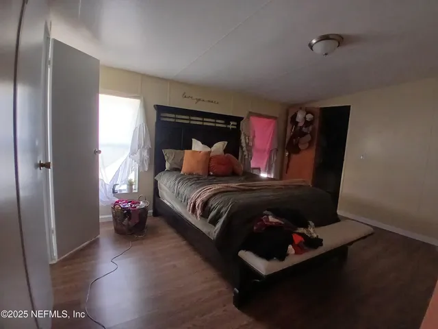 a bedroom with a bed and wooden floor