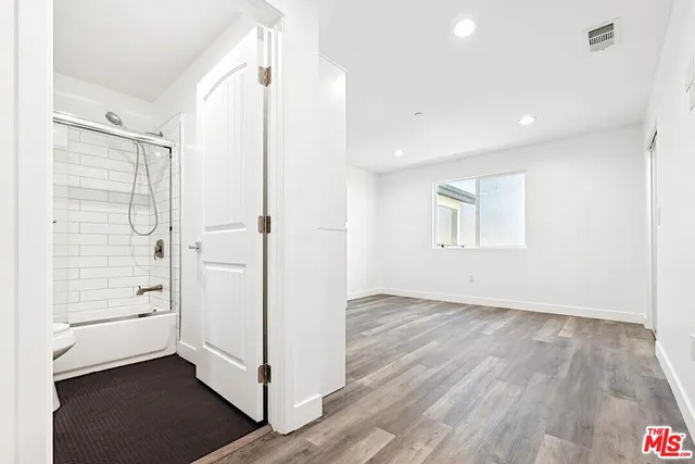 a view of a room with wooden floor and a window