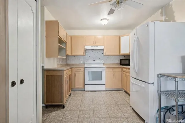 a kitchen with white cabinets and white appliances