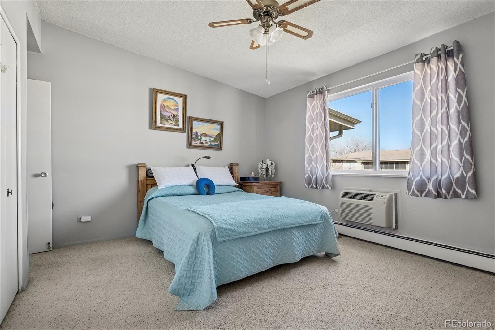 660 South Alton Way, Unit 2D Denver, CO 80247 - Photo 11 of 32 a bedroom with a bed and a chandelier
