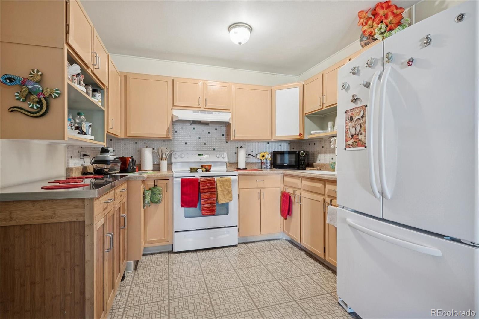 660 South Alton Way, Unit 2D Denver, CO 80247 - Photo 2 of 32 a kitchen with granite countertop a white refrigerator and white cabinets