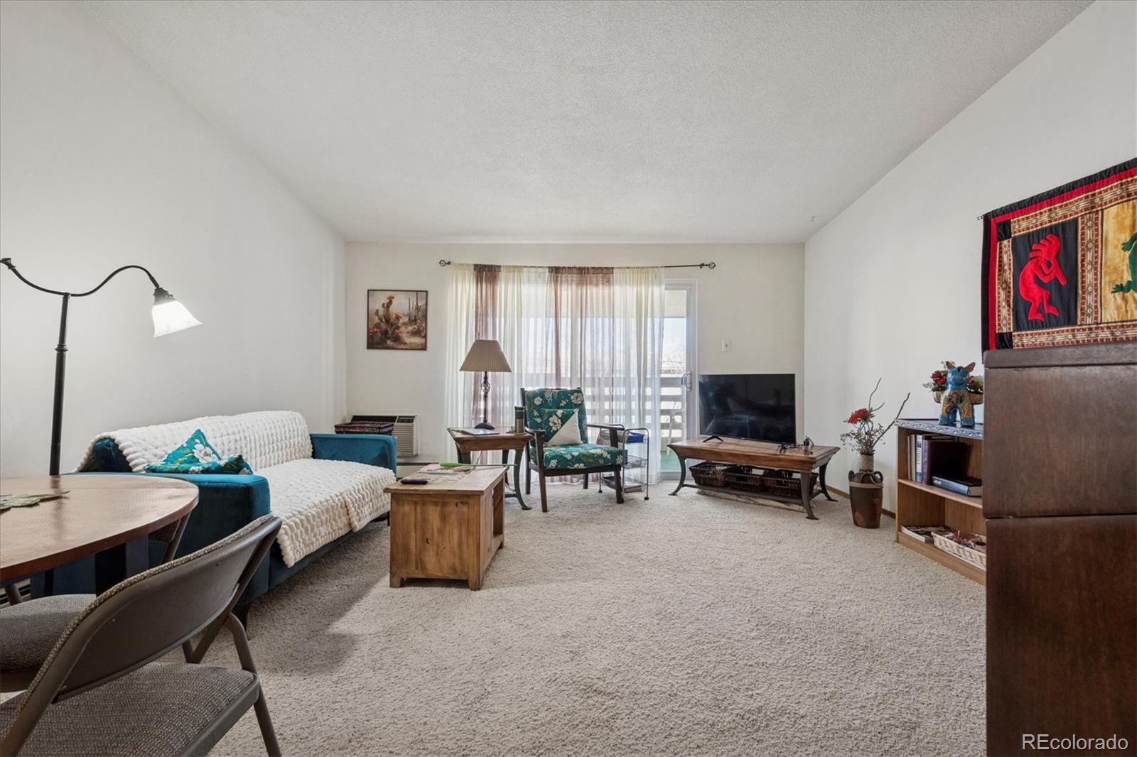660 South Alton Way, Unit 2D Denver, CO 80247 - Photo 7 of 32 a living room with furniture a window and a flat screen tv