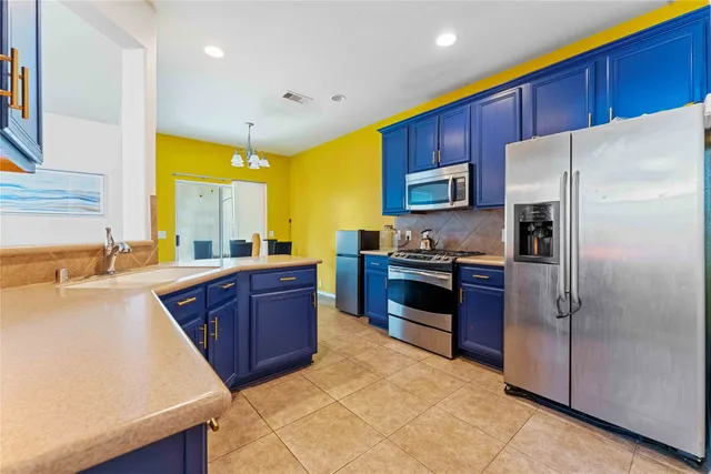 a kitchen with stainless steel appliances granite countertop a refrigerator a stove and a sink
