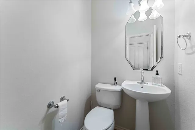 a bathroom with a sink mirror and toilet
