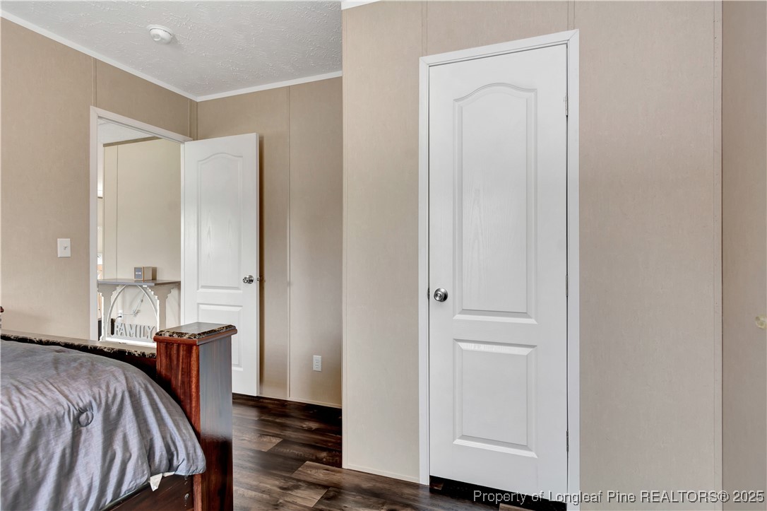 7879 Chicken Road Lumberton, NC 28360 - Photo 23 of 29 a view of a bedroom with a bed and wooden floor