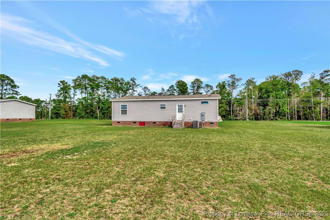 7879 Chicken Road Lumberton, NC 28360 - Photo 27 of 29 a view of a backyard with large trees and plants
