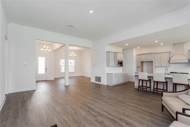 a view of a living room and kitchen with wooden floor