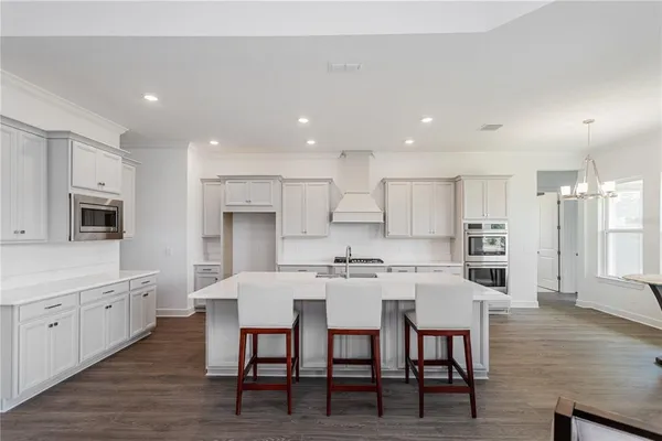 a large kitchen with cabinets table and chairs