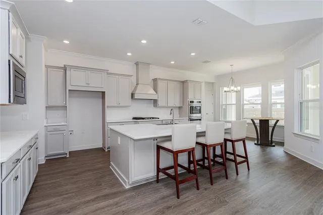 a kitchen with stainless steel appliances a table chairs refrigerator and sink
