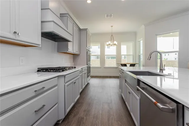 a large kitchen with stainless steel appliances granite countertop a lot of counter space and wooden floors