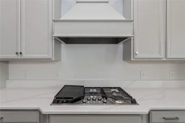 a kitchen with white cabinets and a stove