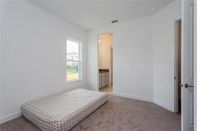 a kitchen with granite countertop a refrigerator a sink and white cabinets